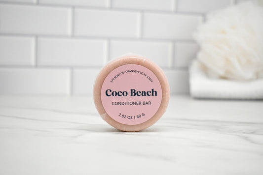 Coco Beach conditioner bar on a white surface with a tiled wall background