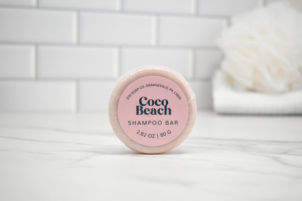 Coco Beach shampoo bar on a white surface with a tiled wall background