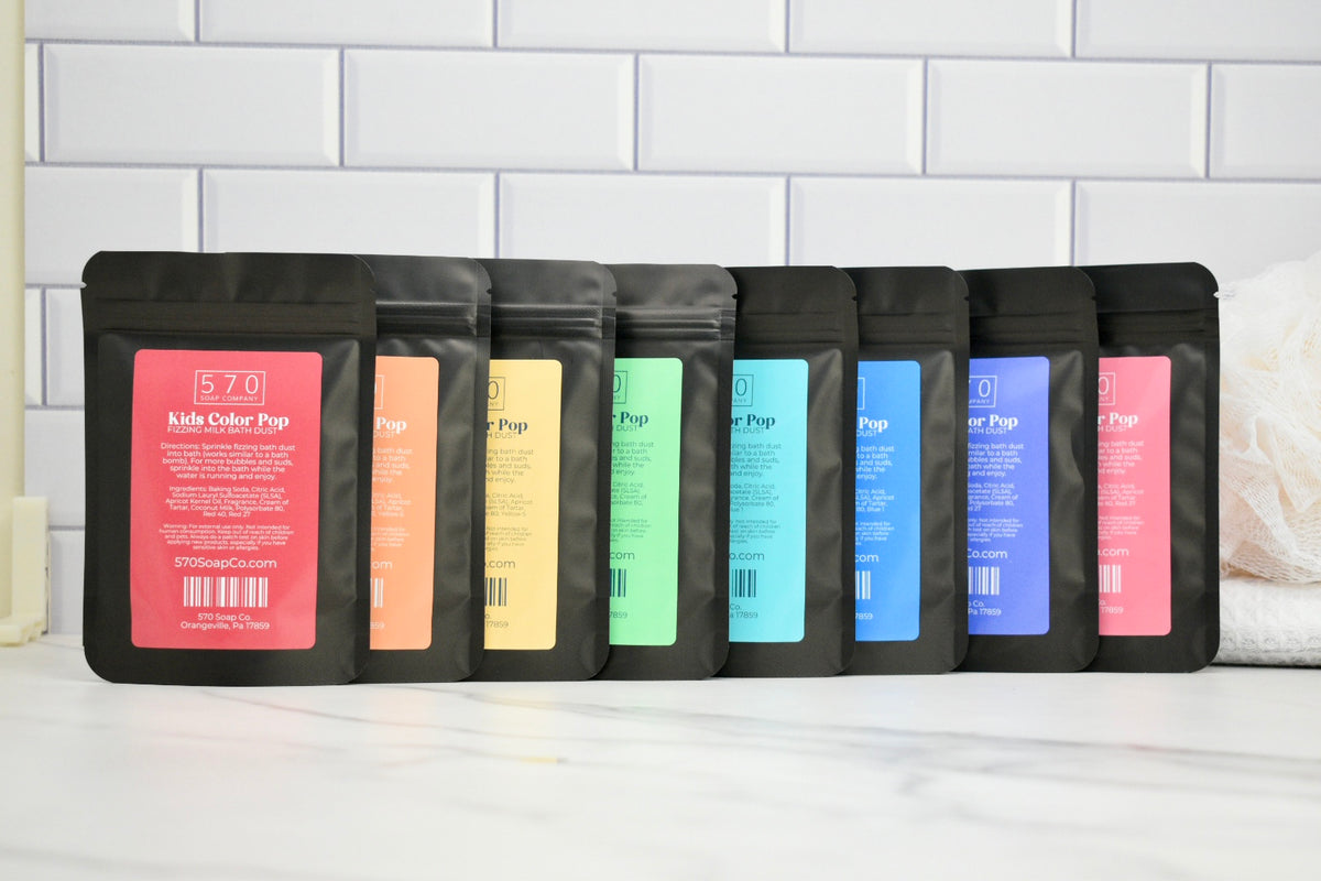 Set of black coffee bags with colorful labels on a white surface.
