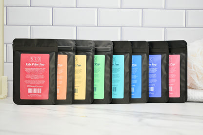 Set of black coffee bags with colorful labels on a white surface.