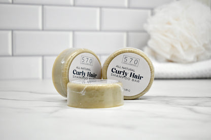 Three shampoo bars labeled '570' on a white surface with a tiled wall background.