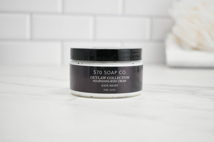 Jar of 570 Soap Co. Outlaw Collection Date Night Nourishing Body Cream on a white surface with a tiled wall background.