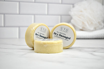 Three shampoo bars with '570' branding on a white surface with a tiled wall background.