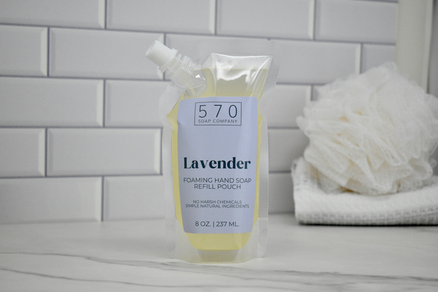 Foaming hand soap refill pouch with lavender scent on a bathroom counter.
