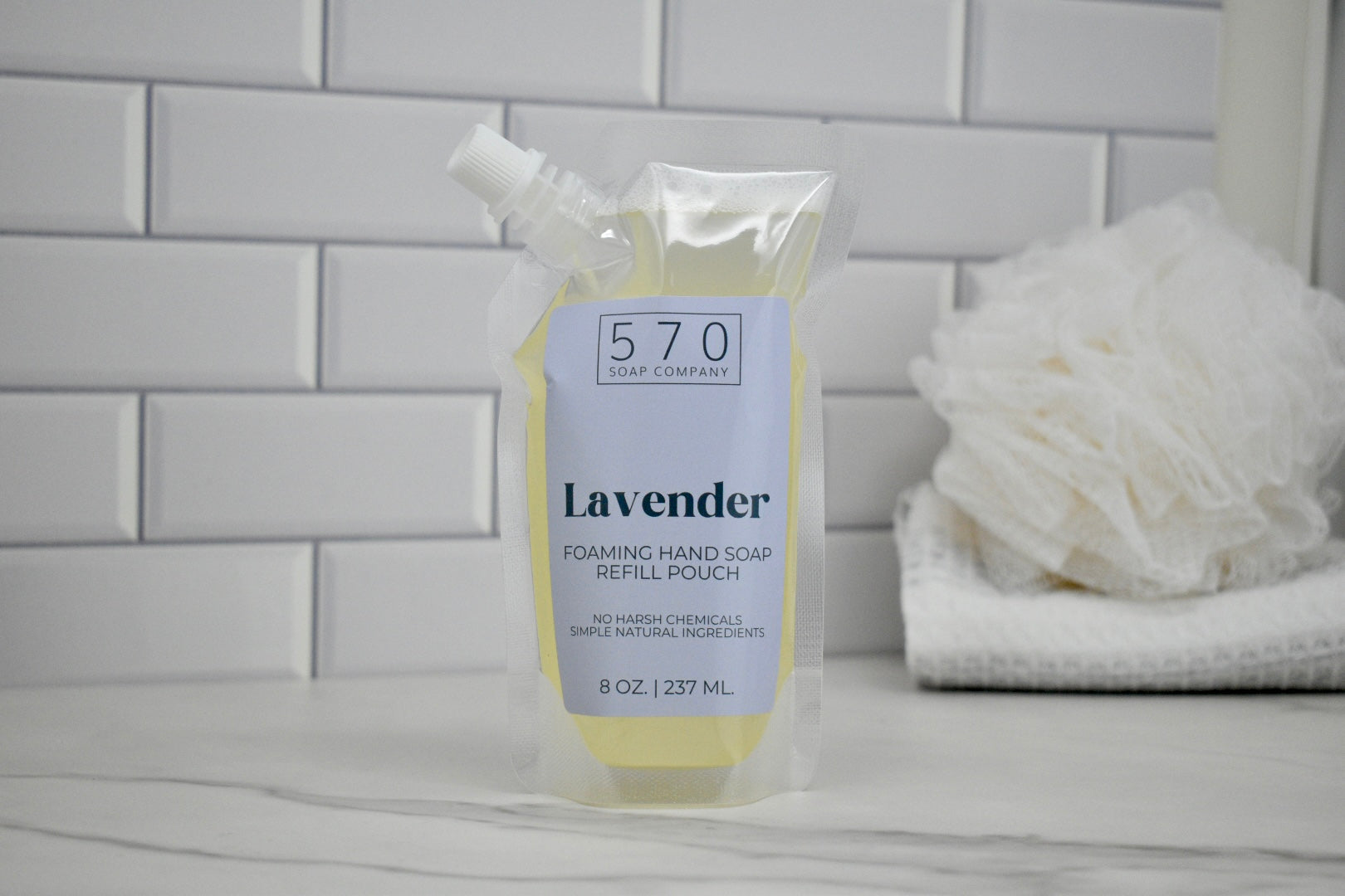 Foaming hand soap refill pouch with lavender scent on a bathroom counter.