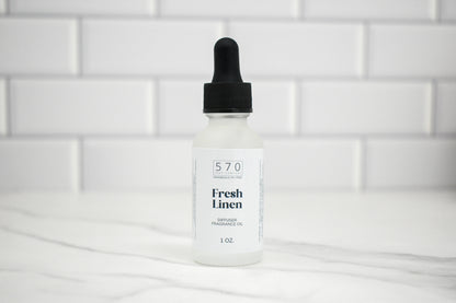 Bottle of 570 Fresh Linen diffuser oil on a white tiled background