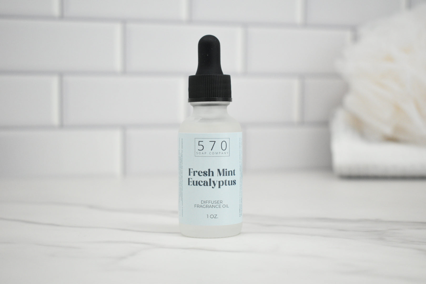 Bottle of 570 Fresh Mint Eucalyptus fragrance oil with dropper on a white tiled background