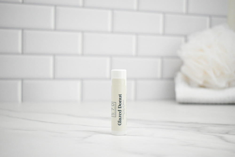 Bottle of Glazed Donut body wash on a bathroom counter with a tiled wall background