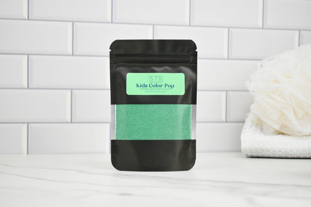 Black pouch with green powder labeled 'Kids Color Pop' on a white tiled background