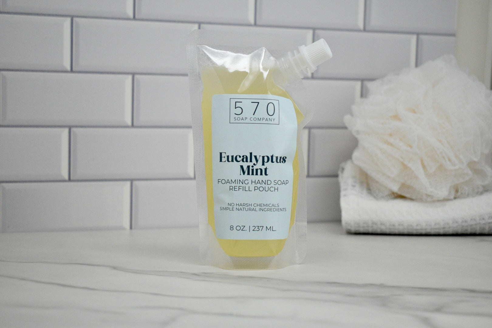 Hand soap refill labeled '570' with 'Eucalyptus Mint' on a bathroom counter.