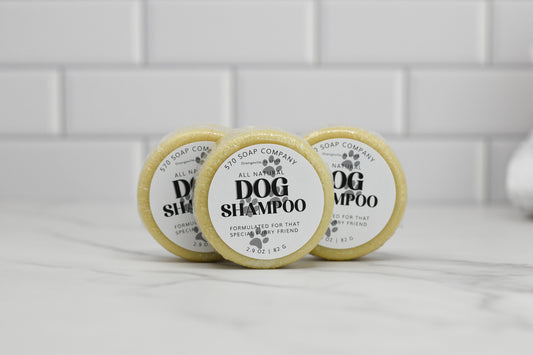 Three round bars of the Dog Shampoo Bar - All Natural from 570 Soap Co. are arranged on a white countertop against a tiled wall. Each bar promises gentle cleansing with a soothing lavender scent.