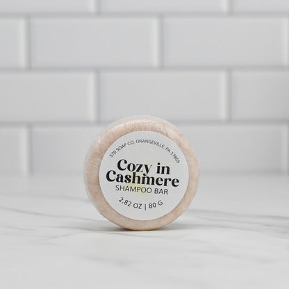 This circular item labeled as the Cozy in Cashmere Shampoo Bar by 570 Soap Co. features nourishing ingredients, making it ideal for eco-conscious hair care.