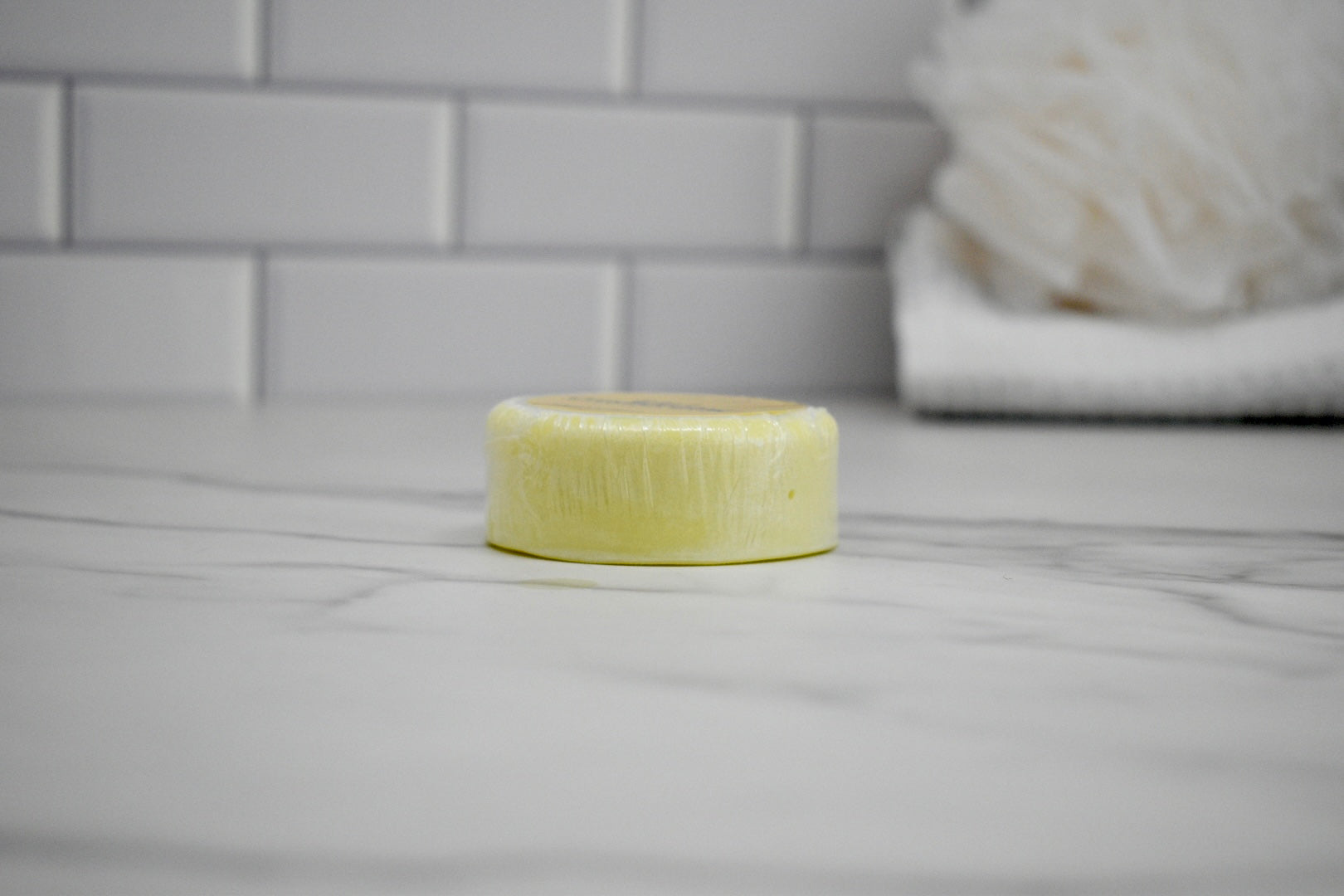 Bar of soap on a bathroom counter with tiled wall in the background