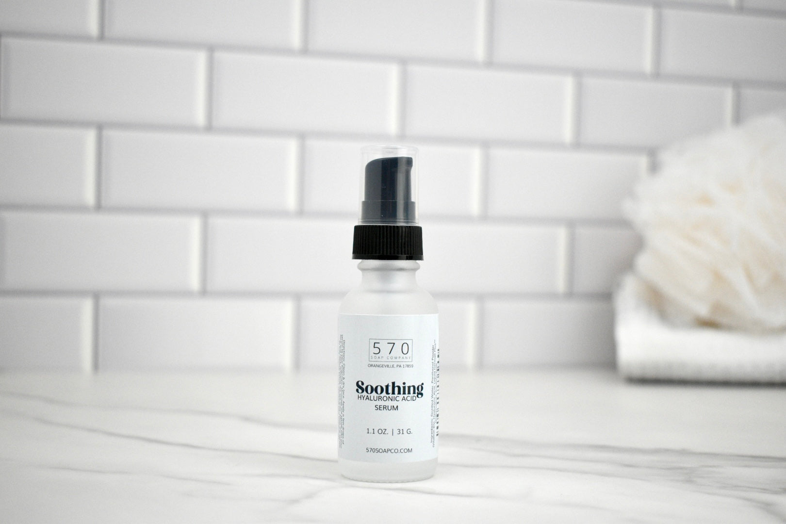 Bottle of 570 Soothing Lotion on a bathroom counter with a white tiled wall background.
