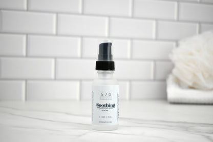 Bottle of 570 Soothing Lotion on a bathroom counter with a white tiled wall background.