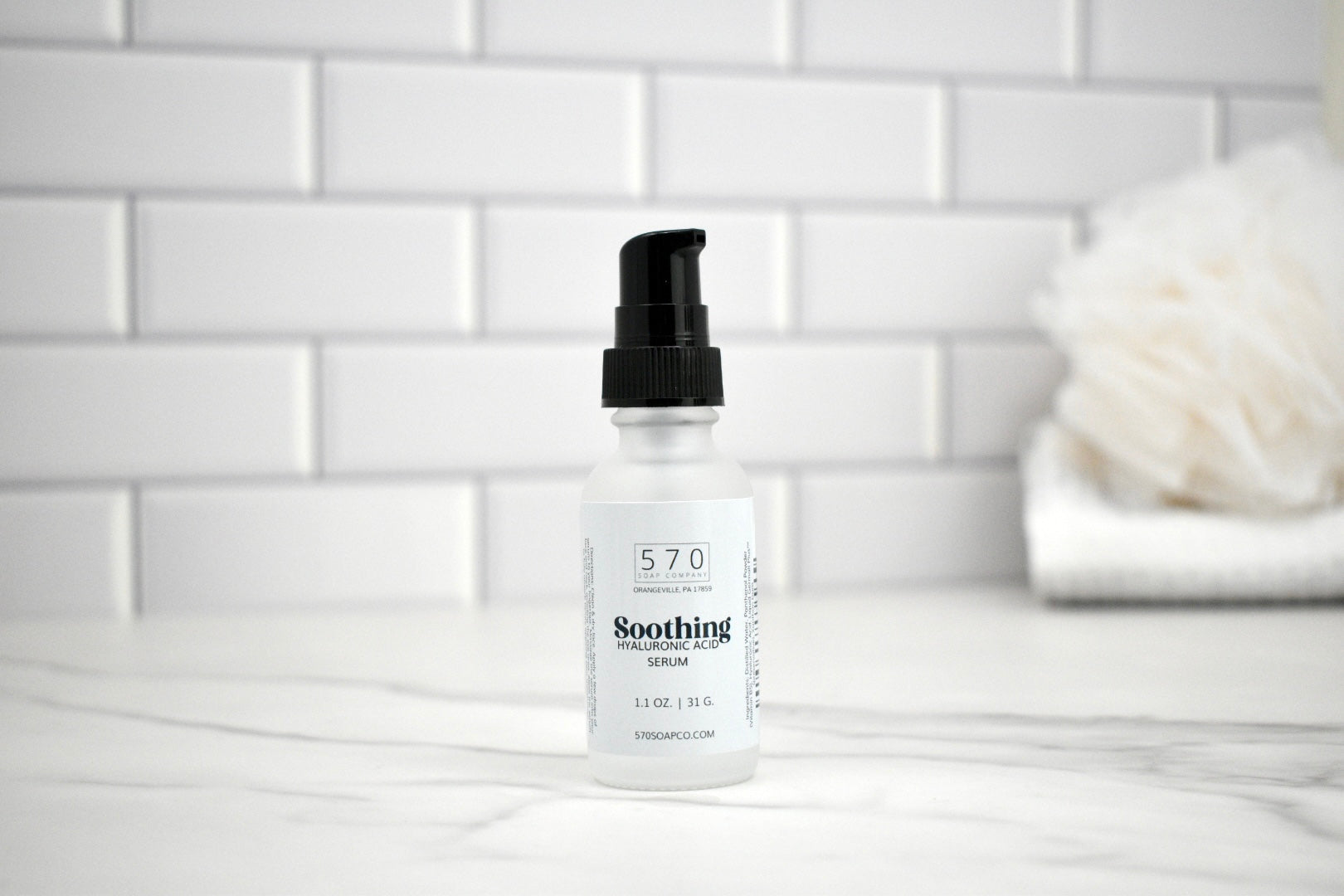 Bottle of 570 Soothing Serum on a white tiled bathroom counter