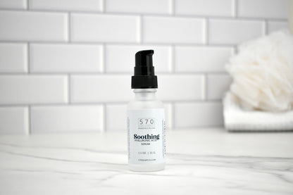 Bottle of 570 Soothing Serum on a white tiled bathroom counter