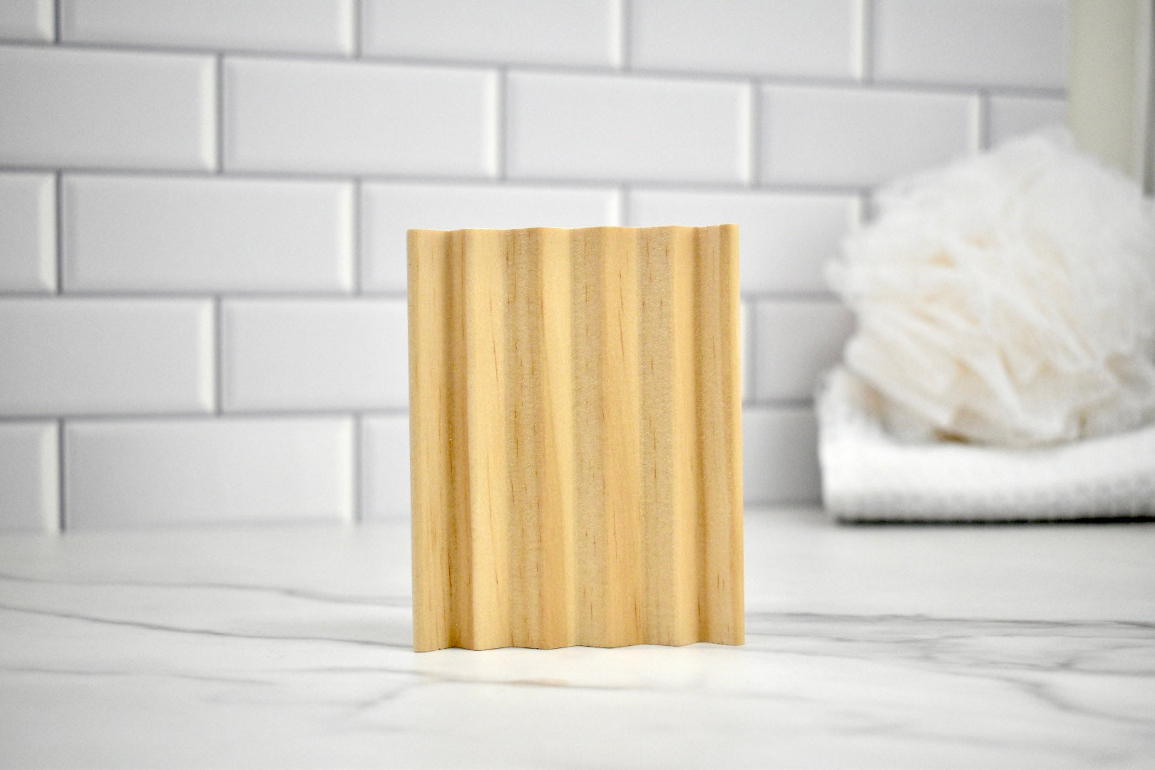 Pine soap dish on a white surface with a tiled wall background