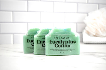 Three bars of Eucalyptus Cotton soap from 570 Soap Co on a white tiled background