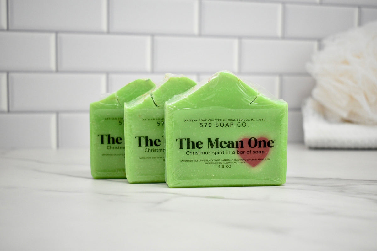 Three green bars of soap with 'The Mean One' branding on a white surface.