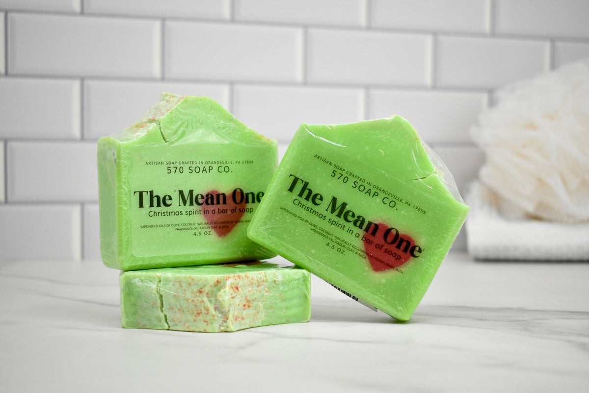 Green soap bars from The Mean One with visible branding on a white surface.