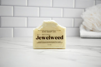 Bar of Jewelweed soap from 570 Soap Co on a white surface with a tiled wall background.