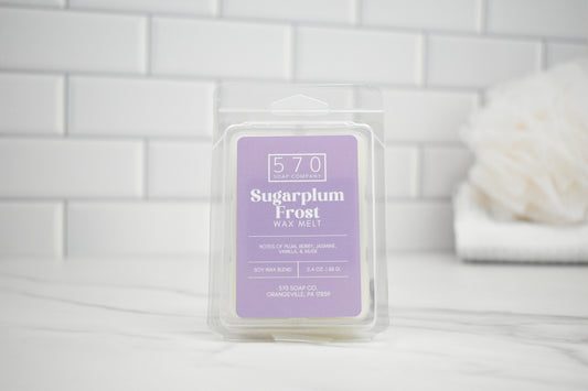 Packaged wax melt labeled 'Sugarplum Frost' on a white tiled background