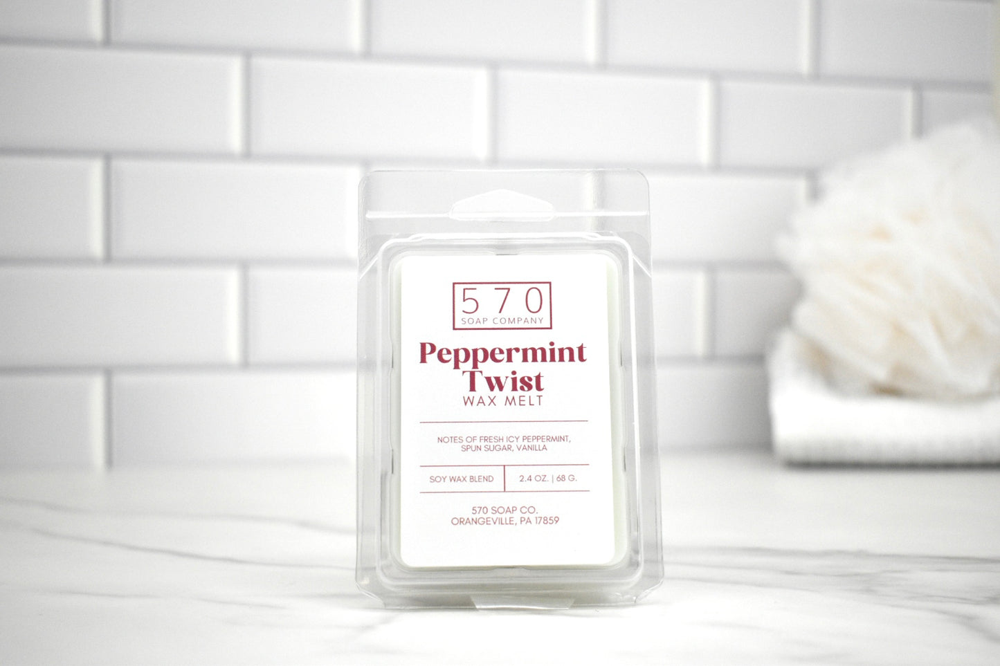 570 Peppermint Twist wax melt packaging on a white surface with a tiled wall background