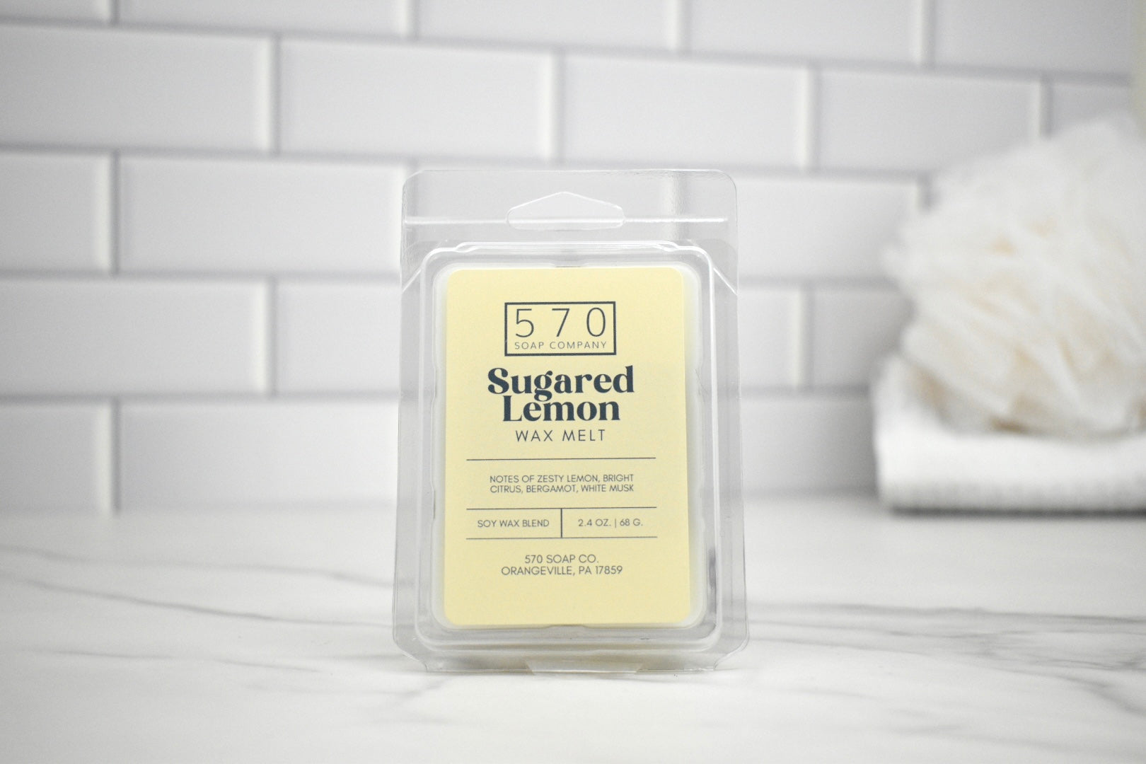 Sugared Lemon wax melt packaging on a white tiled background
