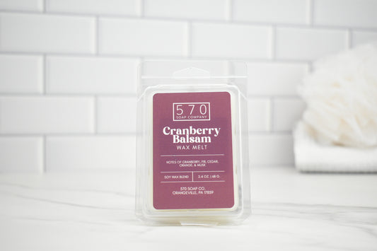 Packaged cranberry balsam wax melt with 570 Soap & Co branding on a white tiled background.