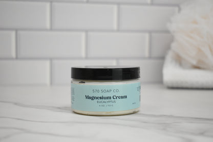 Jar of eucalyptus magnesium cream from 570 Soap Co. on a bathroom counter.
