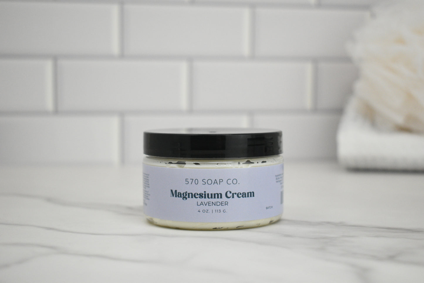 Jar of lavender magnesium cream from 570 Soap Co. on a bathroom counter.