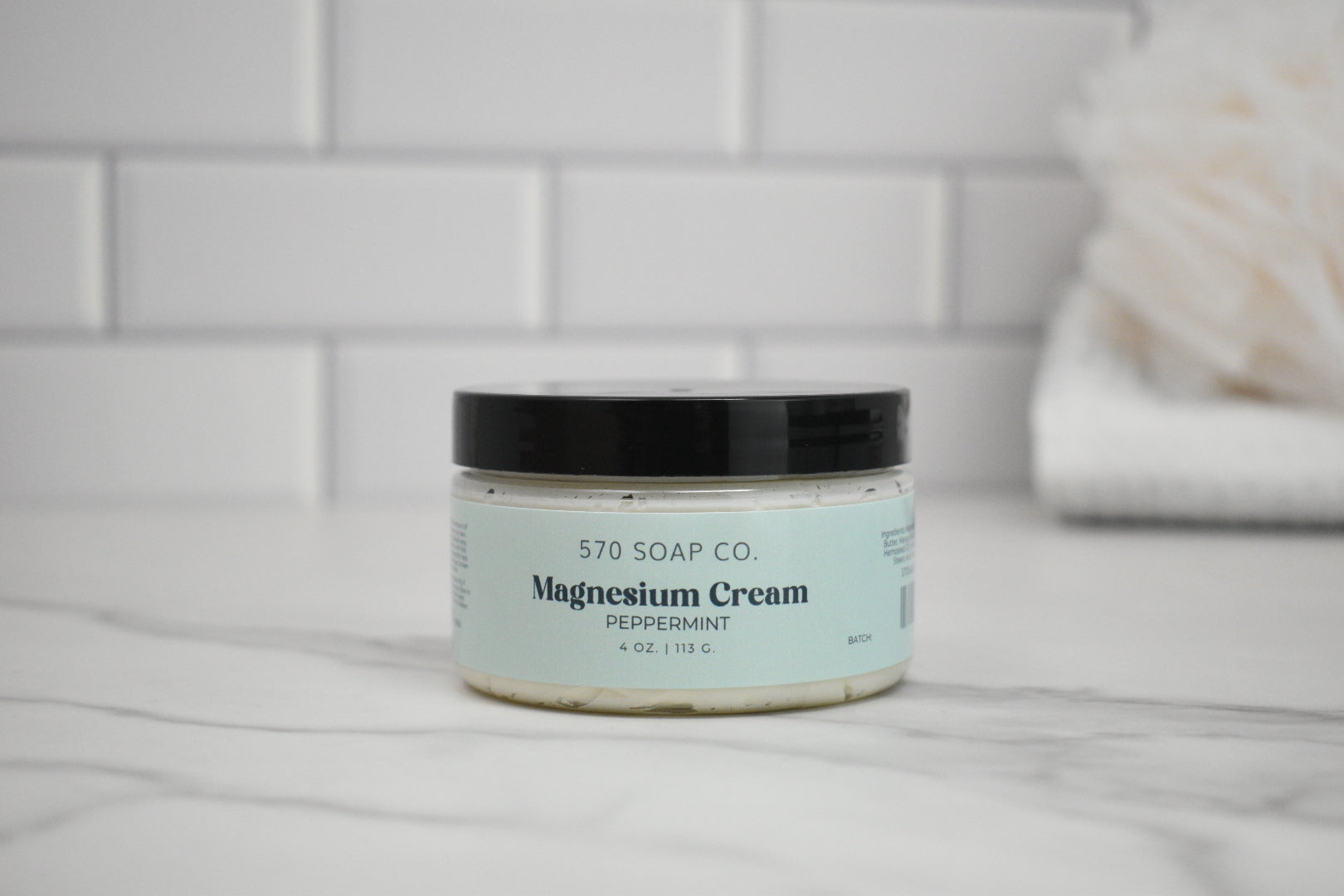 Jar of peppermint magnesium cream from 570 Soap Co. on a bathroom counter.