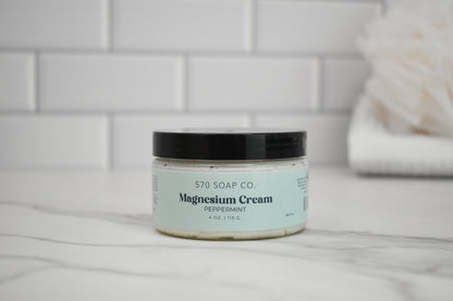 Jar of peppermint magnesium cream from 570 Soap Co. on a bathroom counter.