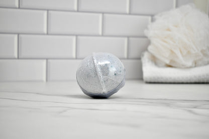 Bath bomb on a bathroom counter with a white tiled wall in the background