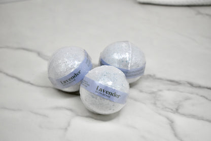 Three lavender bath bombs on a marble surface