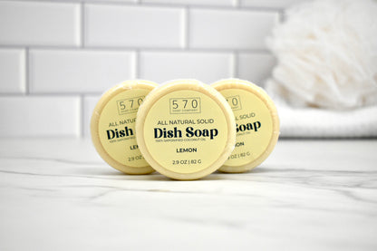 Three containers of 570 Dish Soap on a white surface with a tiled wall background.