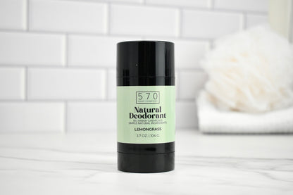 570 Natural Deodorant stick on a white surface with a tiled wall background