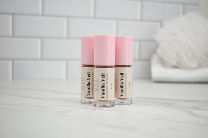 Three Vanilla Veil lip balm tubes with pink caps on a white surface.