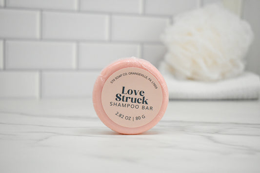 Love Struck shampoo bar on a white surface with a tiled wall background