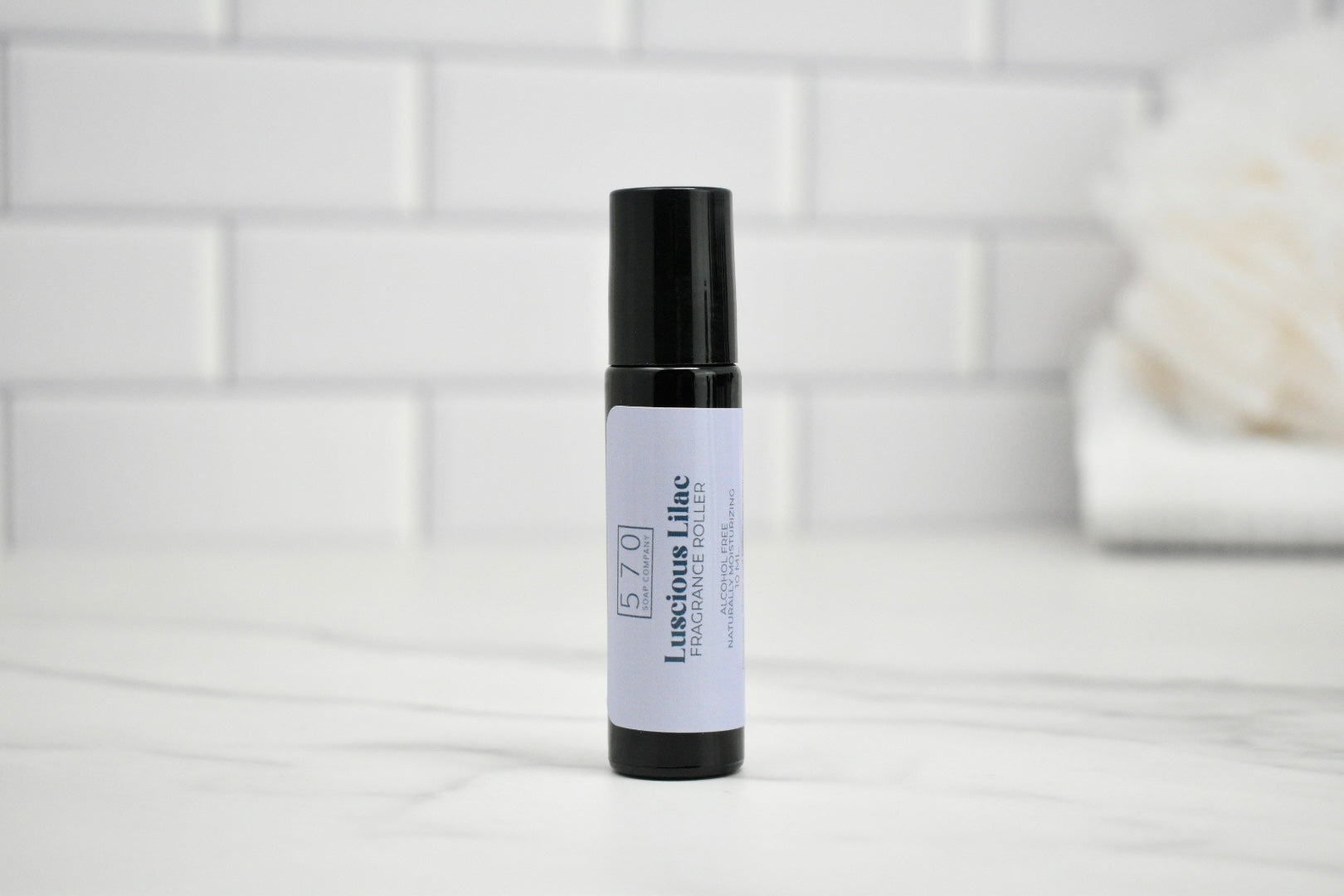 Skincare serum bottle with a white label on a light gray surface.