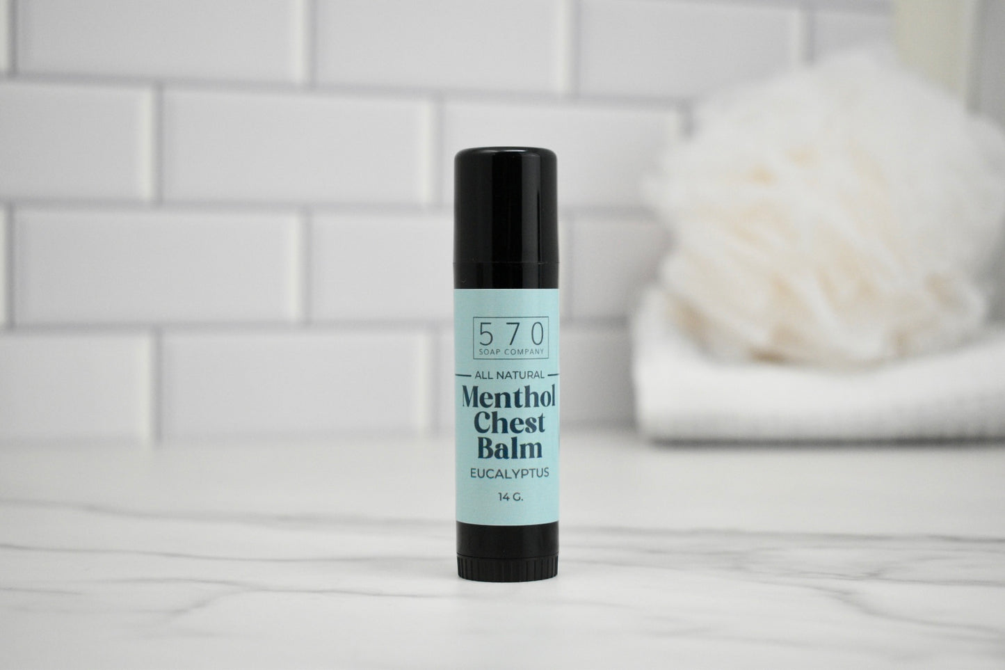 Bottle of 570 Menthol Chest Balm on a white surface with a blurred background