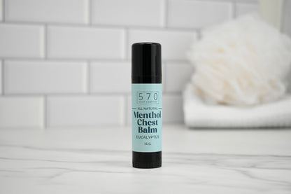 Bottle of 570 Menthol Chest Balm on a white surface with a blurred background
