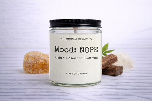 Candle labeled 'Mood: NOPE' with ingredients displayed on a white background