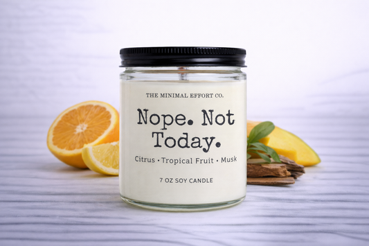 Candle labeled 'Nope. Not Today.' with citrus and tropical fruit scents on a white background