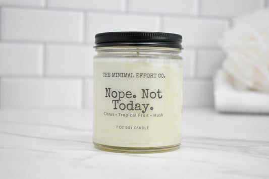 Candle jar labeled 'Nope. Not Today.' by The Minimal Effort Co. on a white surface with a tiled wall background.