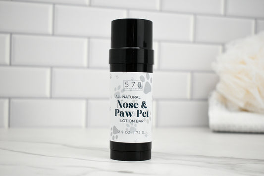 Bottle of 570 Nose & Paw Pet Lotion Bar on a white surface with a tiled wall background