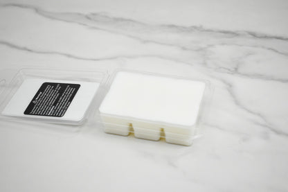 White wax melt container with a label on a marble surface