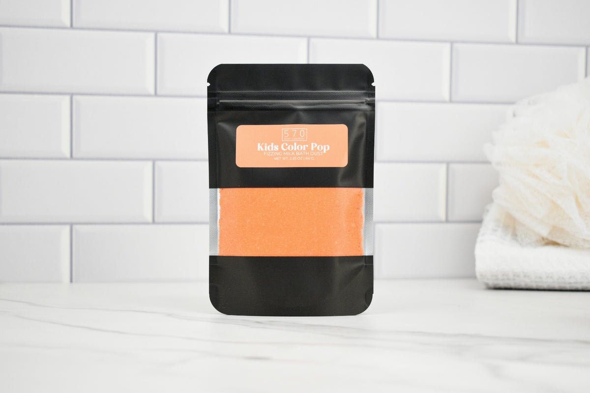 Black packaging with peach-colored product on a white tiled background