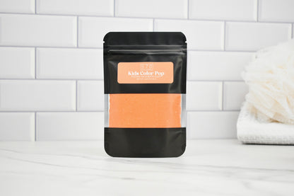 Black packaging with peach-colored product on a white tiled background